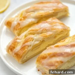 Three slices of cream cheese danish on white plate.