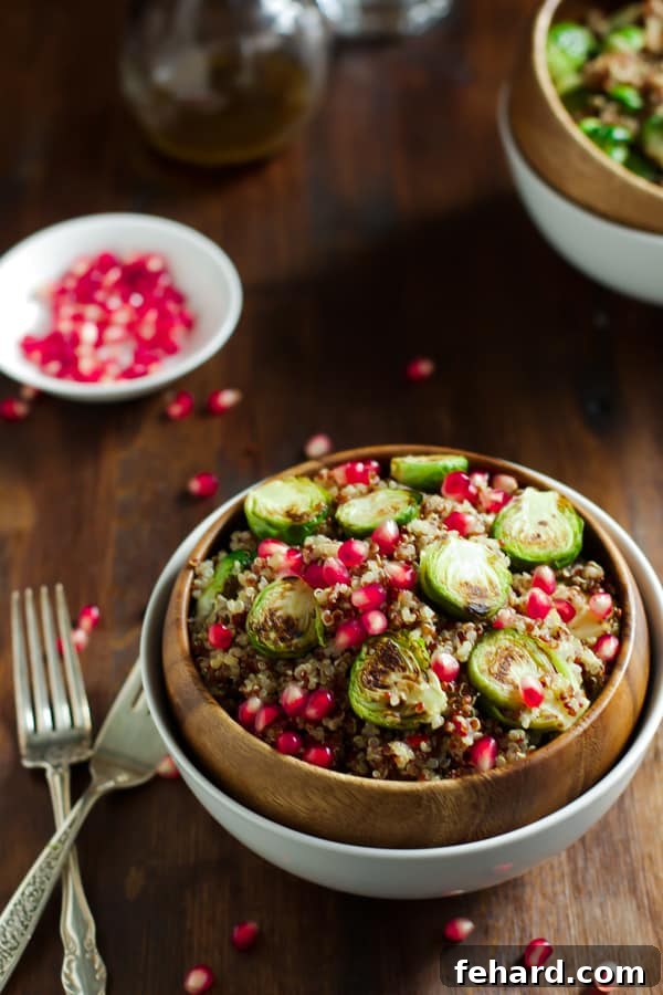 Crispy Roasted Brussels Sprouts Quinoa Bowl 3 Close-up of a colorful Quinoa Salad featuring roasted Brussels sprouts, vibrant pomegranate seeds, and fresh greens.