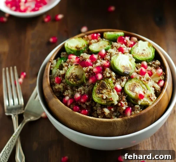 Crispy Roasted Brussels Sprouts Quinoa Bowl 4 Overhead view of a vibrant Roasted Brussels Sprouts Quinoa Salad with pomegranate and fresh herbs in a serving bowl.
