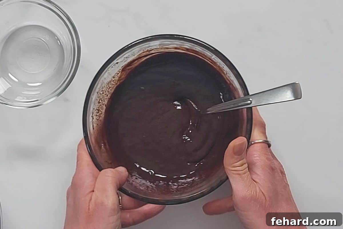 Instapot Chocolate Cheesecake A bowl of glossy, smooth melted chocolate chips, ready to be incorporated into the cheesecake batter.