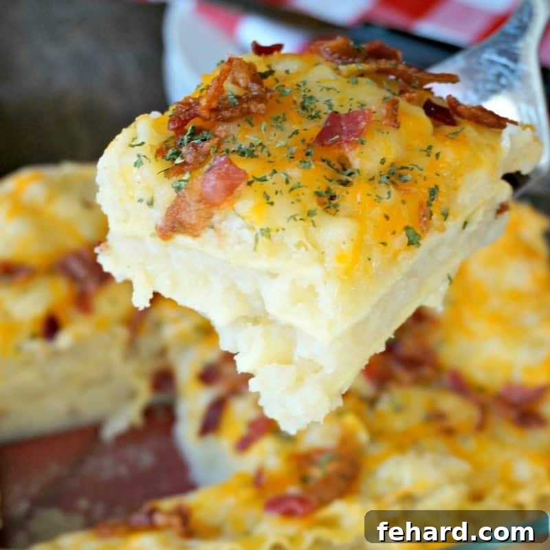 A slice of golden-baked Pierogi Lasagna being lifted with a spatula, showing layers of noodles, mashed potatoes, and cheese.