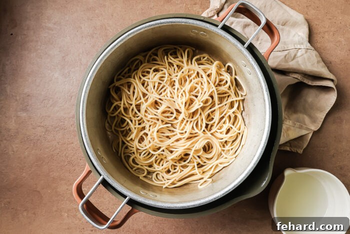 Drained cooked spaghetti resting in a large pot, perfectly al dente and ready for the sauce.