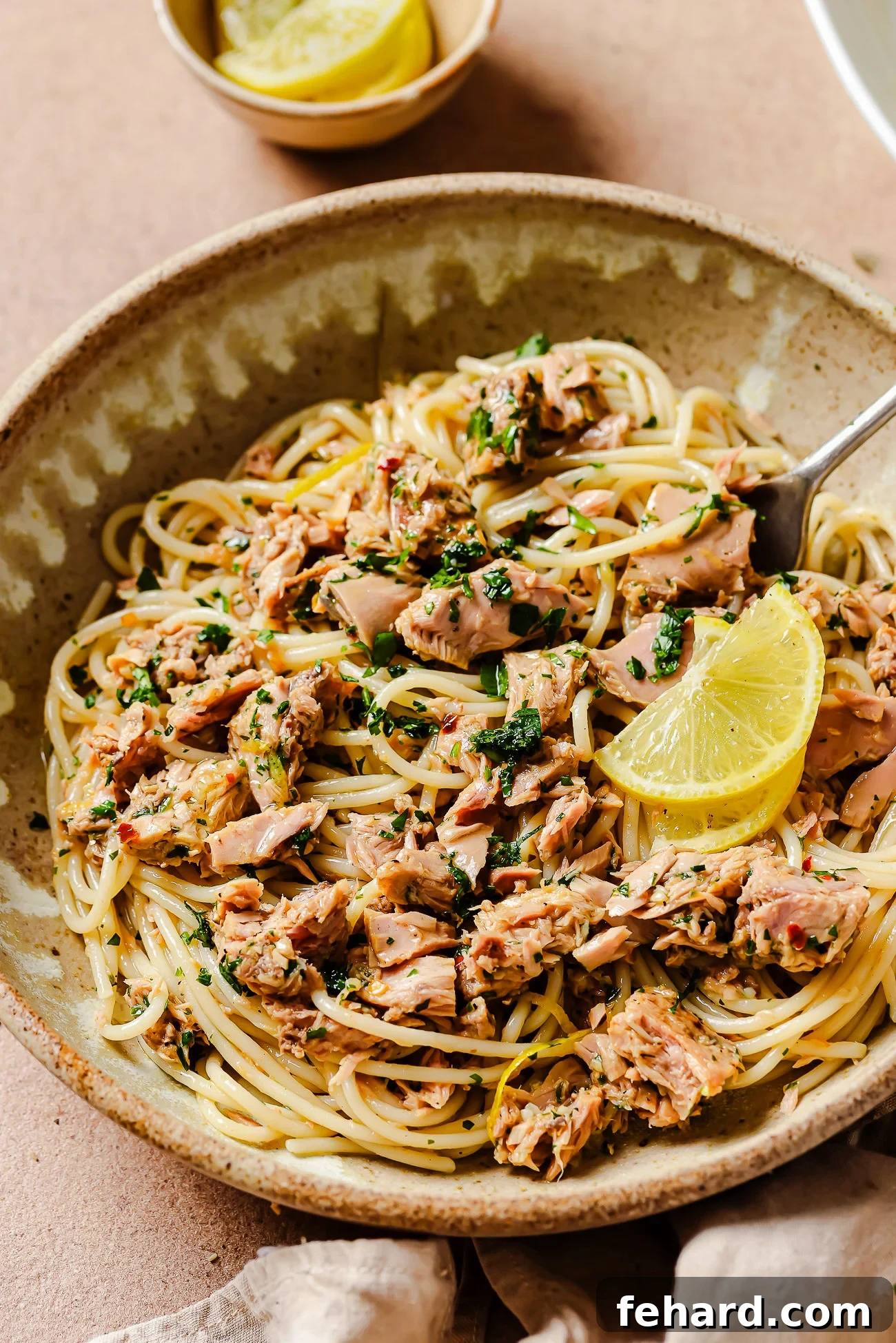 A beautifully presented bowl of homemade tuna pasta, garnished with fresh herbs, showcasing its rich texture and vibrant colors.