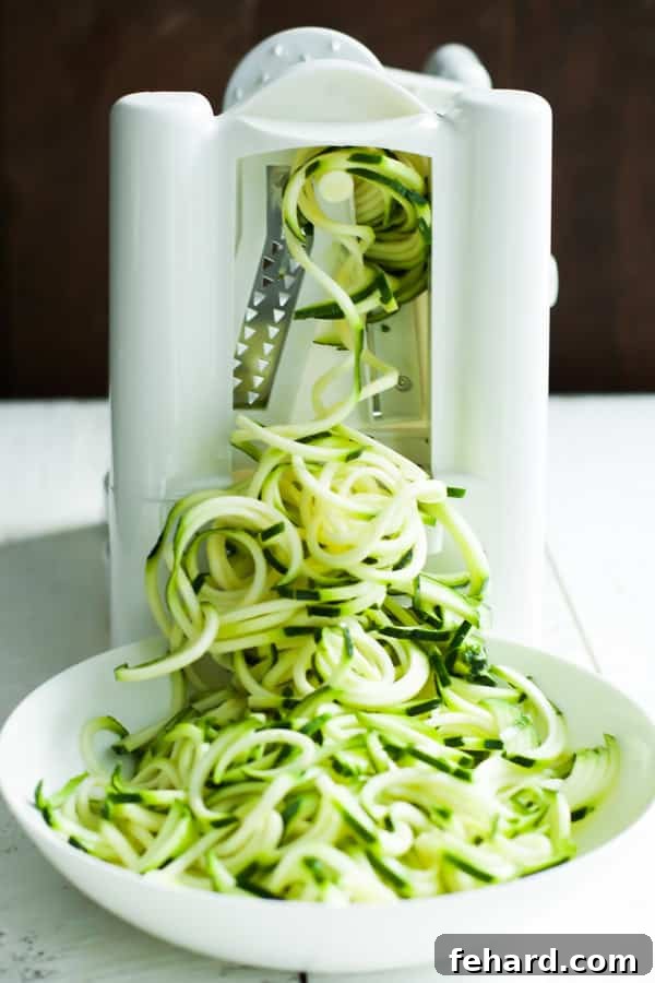 Close-up shot of a spiralizer creating fresh zucchini noodles.