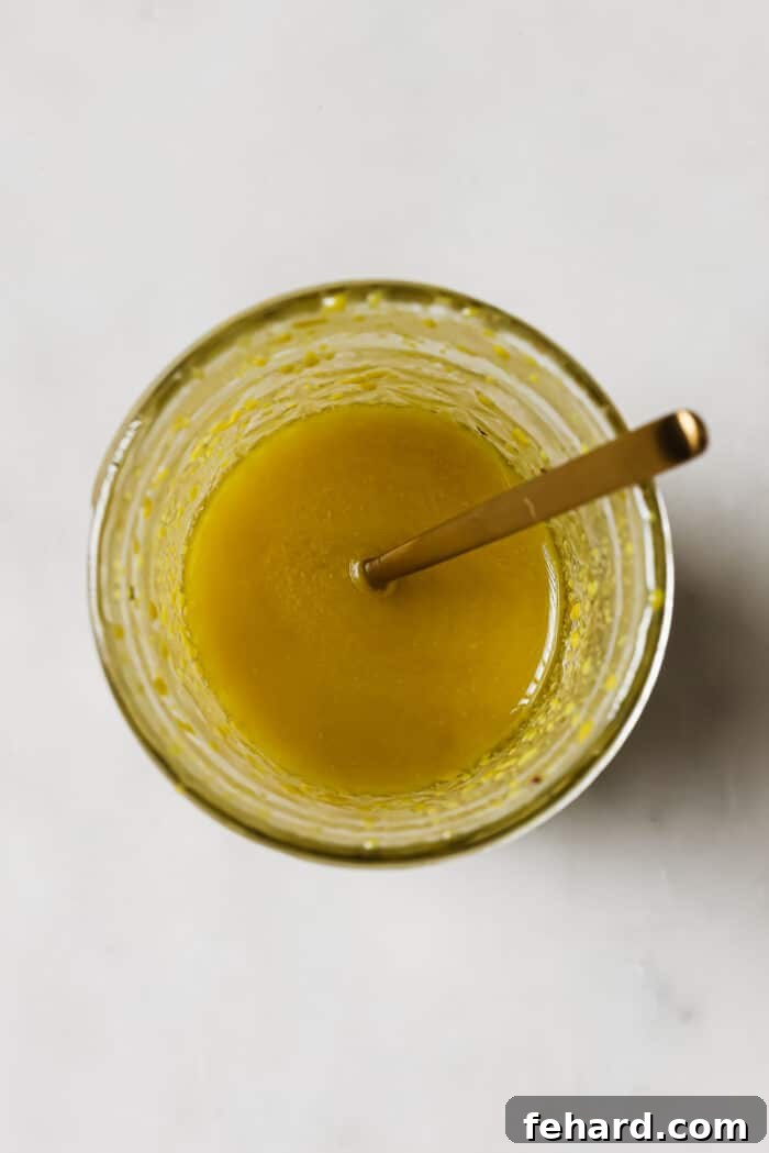 Quick & Fresh Breakfast Salad 5 A mason jar of salad dressing with a gold spoon in it.