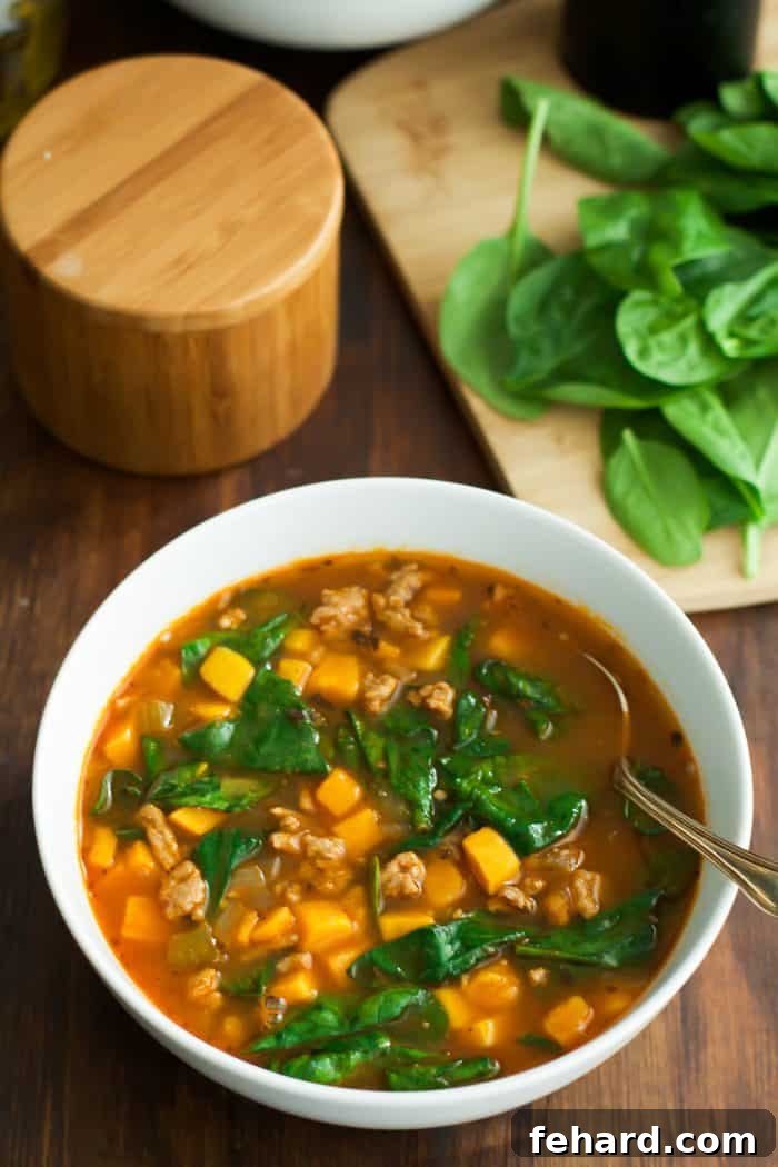60 Delicious Whole30 Recipes 7 A close-up of a vibrant sweet potato and spinach soup, rich and creamy, served in a pristine white bowl.