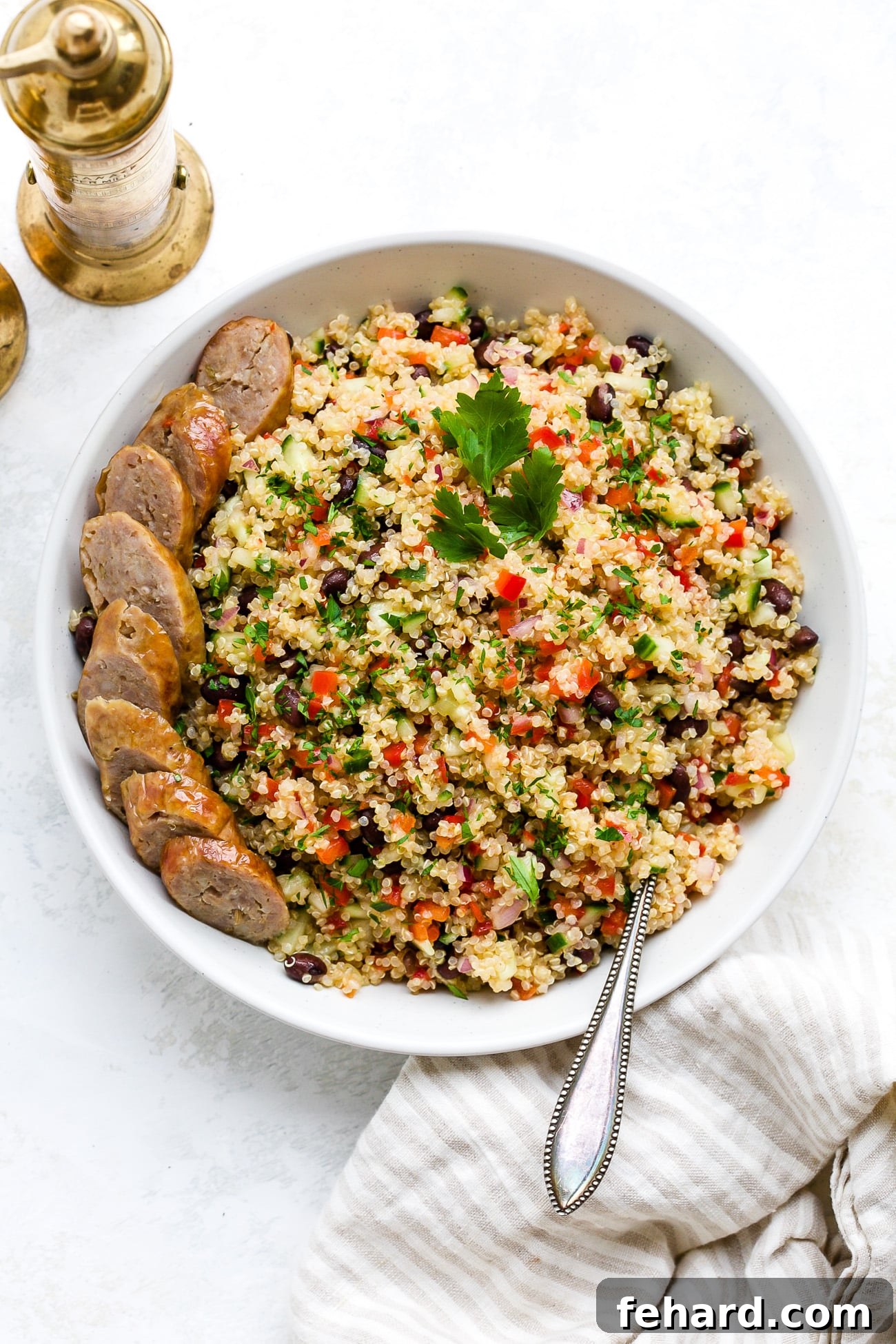 A large white serving bowl filled with a colorful and hearty quinoa salad, ideal for a family picnic.
