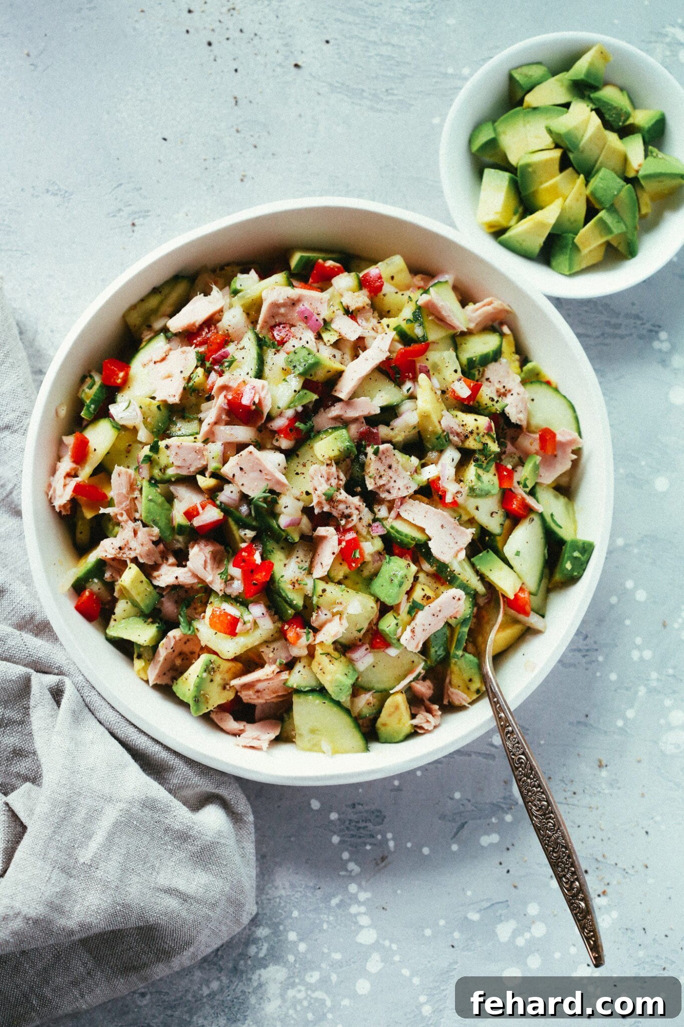 Creamy avocado tuna salad in a white bowl, a refreshing and easy-to-pack picnic option.