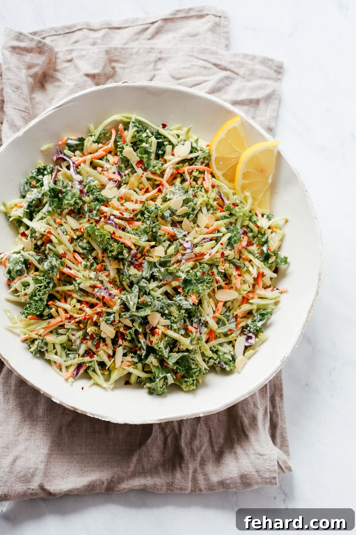 Overhead view of a vibrant broccoli kale slaw salad in a white bowl, a quick and healthy picnic option.