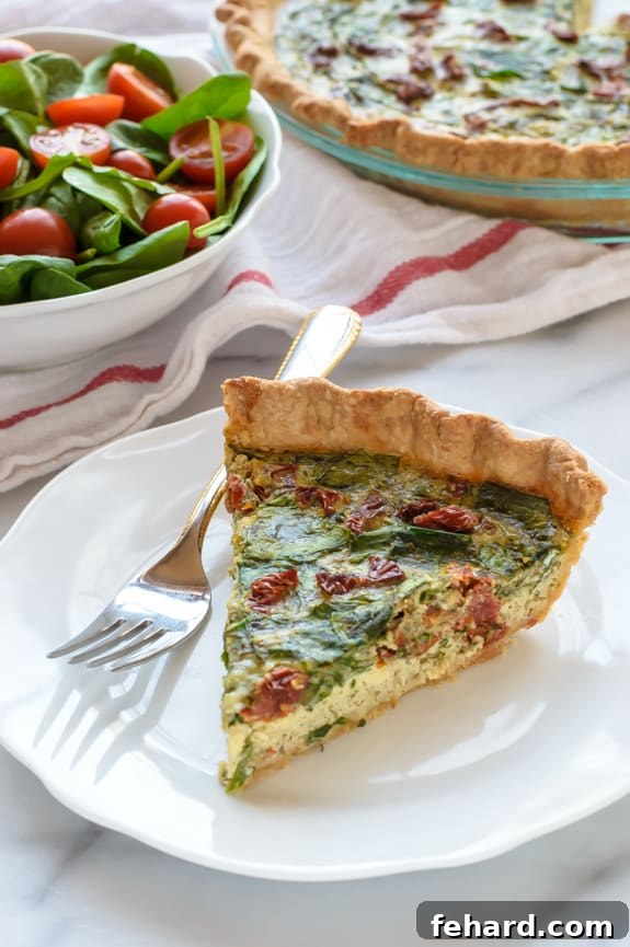 A tempting slice of pesto quiche with sun-dried tomatoes and parmesan, a perfect portable picnic meal.