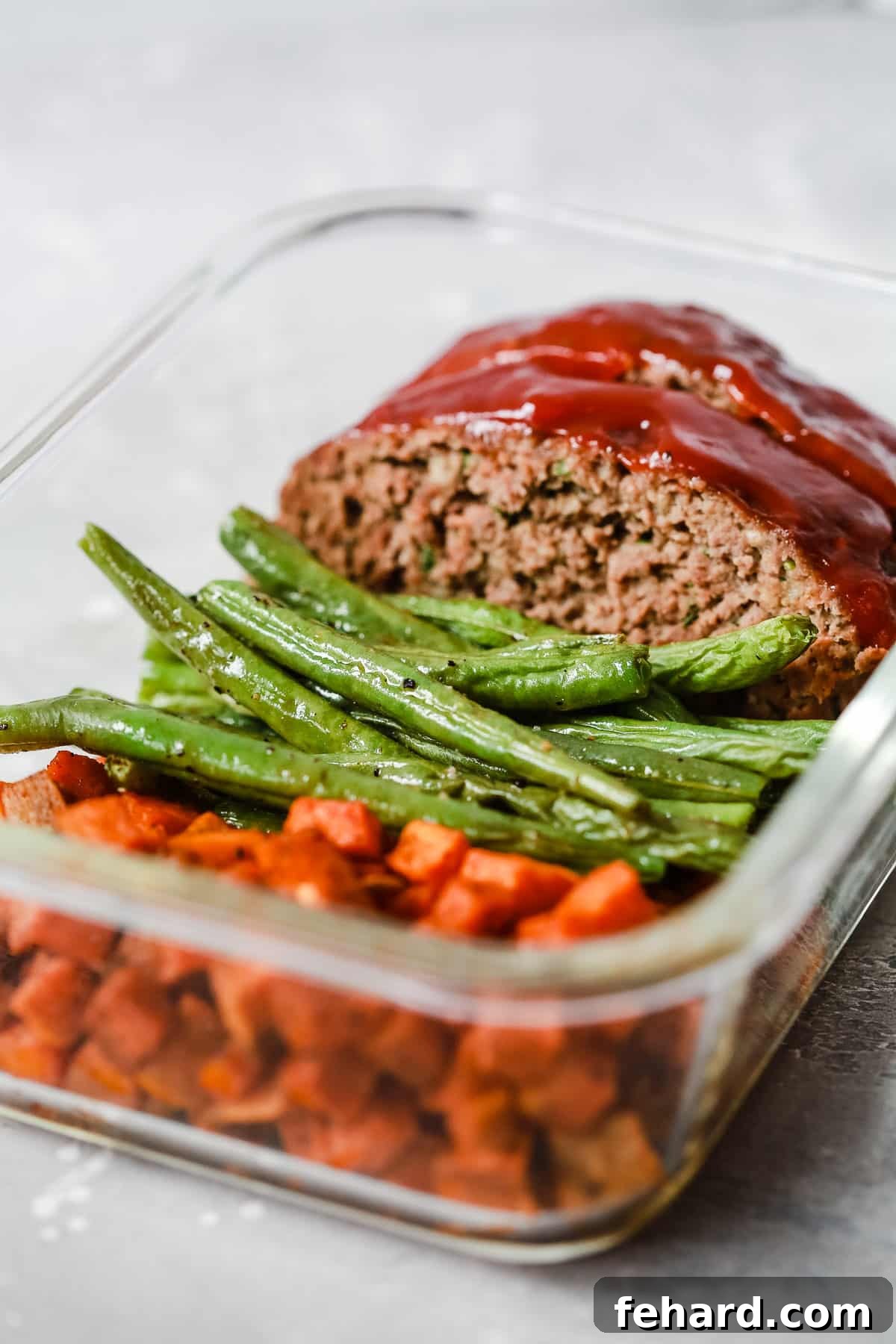 Healthy Meatloaf Meal-Prep Bowls, showing close-up of the delicious meatloaf and roasted vegetables.