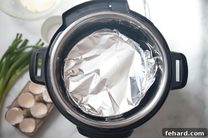 A covered cake pan containing the Instant Pot Frittata mixture, carefully placed on a trivet inside the Instant Pot's inner pot, ready for pressure cooking.