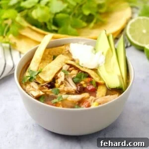 Hearty Instant Pot Chicken Tortilla Soup 2 Instant Pot Chicken Tortilla Soup in bowl topped with homemade tortilla strips, sour cream, and sliced avocado.