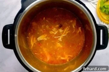 Hearty Instant Pot Chicken Tortilla Soup 8 Shredded chicken stirred into inner pot with base for tortilla soup.