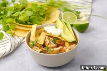 Hearty Instant Pot Chicken Tortilla Soup 9 Instant Pot Chicken Tortilla Soup in bowl topped with homemade tortilla strips, sour cream, and sliced avocado.