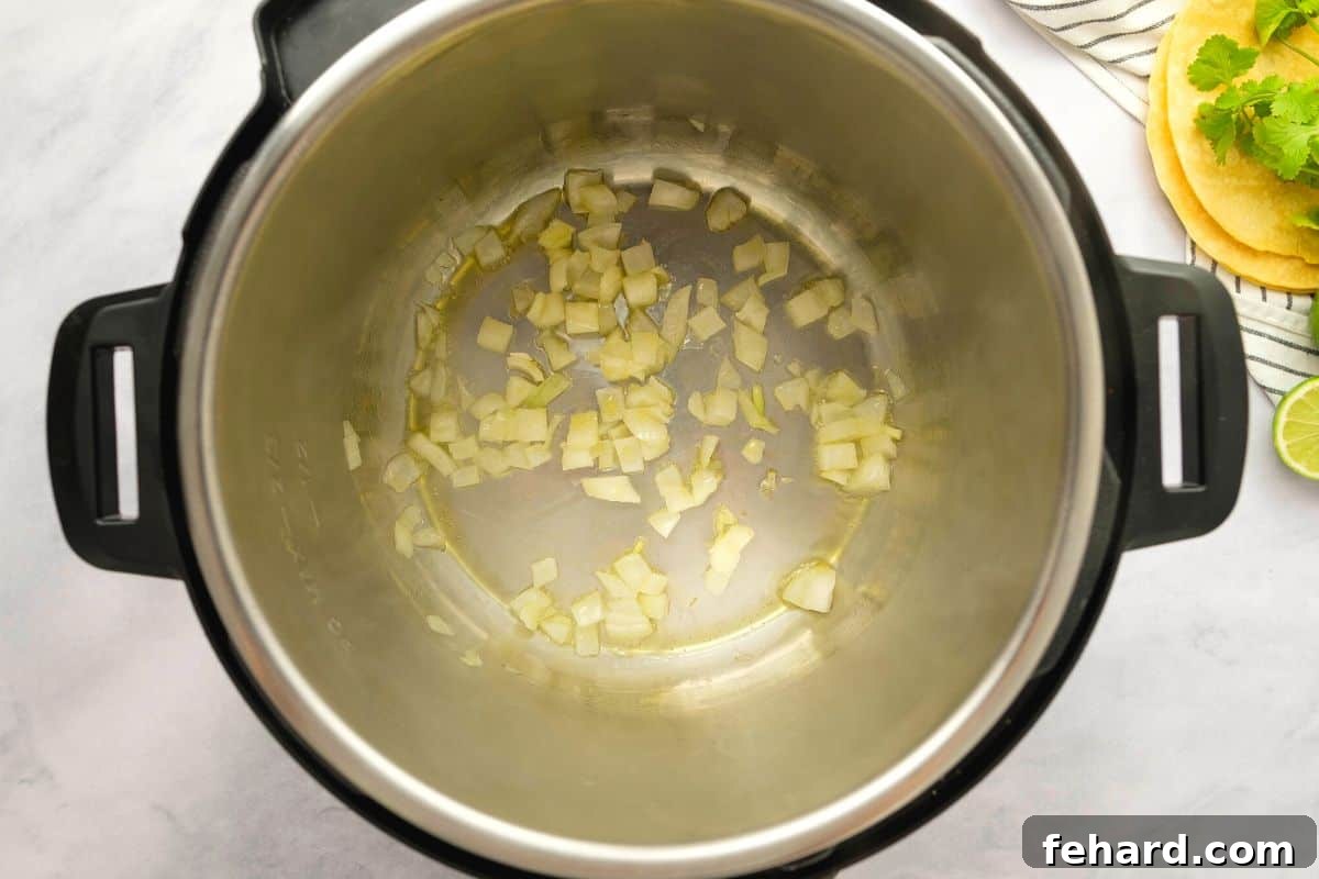 Instant Pot Tortilla Soup Sauteed onion in oil in inner pot.