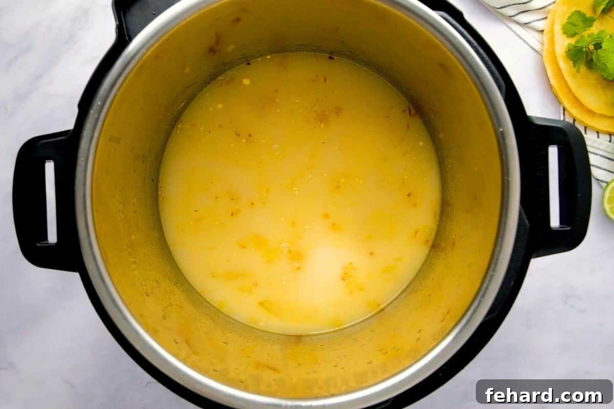 Easy Instant Pot Tortilla Soup Chicken stock added to inner pot after sauteeing onions and garlic to build Instant Pot Chicken Tortilla Soup.