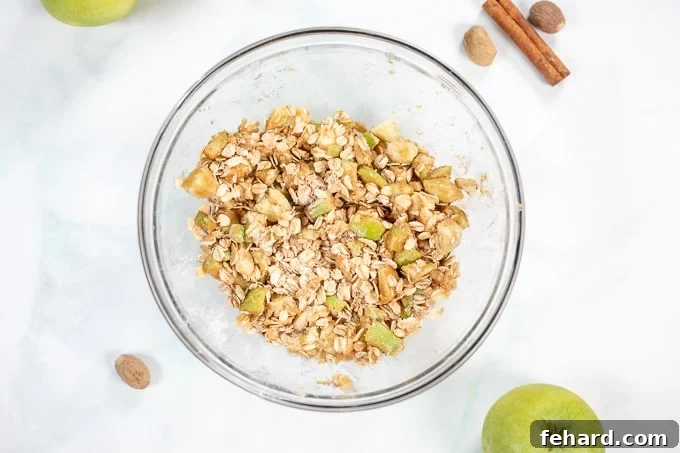 Oat crumble for baked apples in a clear mixing bowl