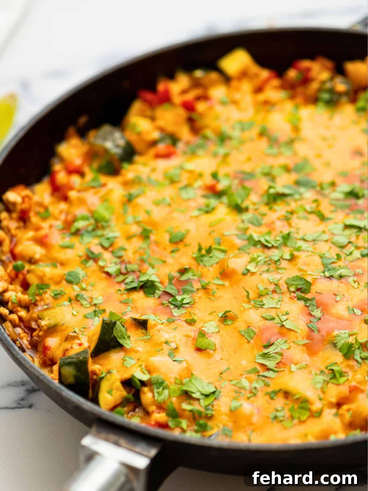 Turkey Taco Skillet Recipe Cheesy taco skillet made with lean ground turkey in a large skillet, topped with fresh cilantro, ready to serve.