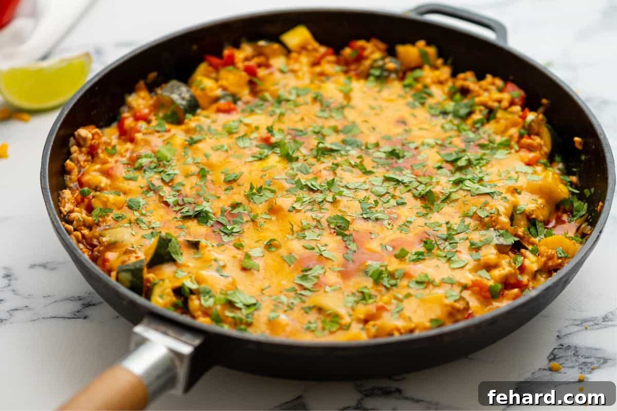 Cheesy Turkey Taco Skillet The completed taco skillet, generously smothered in melted cheese, fresh out of the pan and ready to be served.
