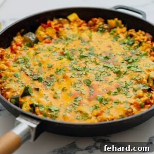 A top-down view of the skillet with seasoned ground turkey and vegetables, preparing for the final steps of the taco skillet.