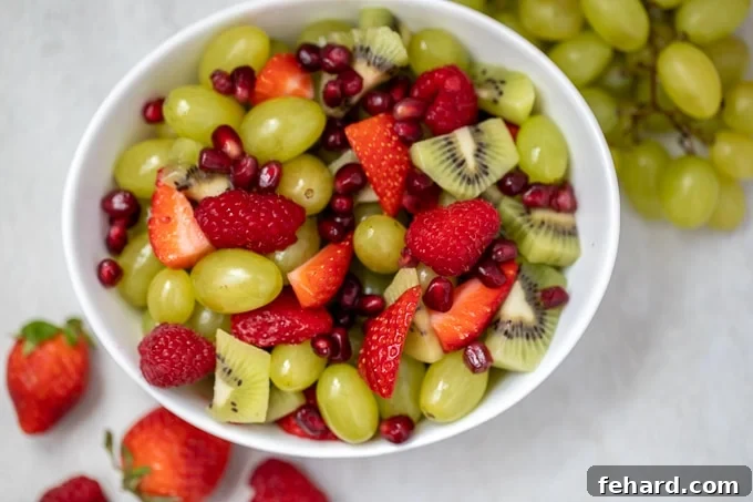 Red and Green Fruit Salad in a beautiful white bowl, perfectly arranged for serving.