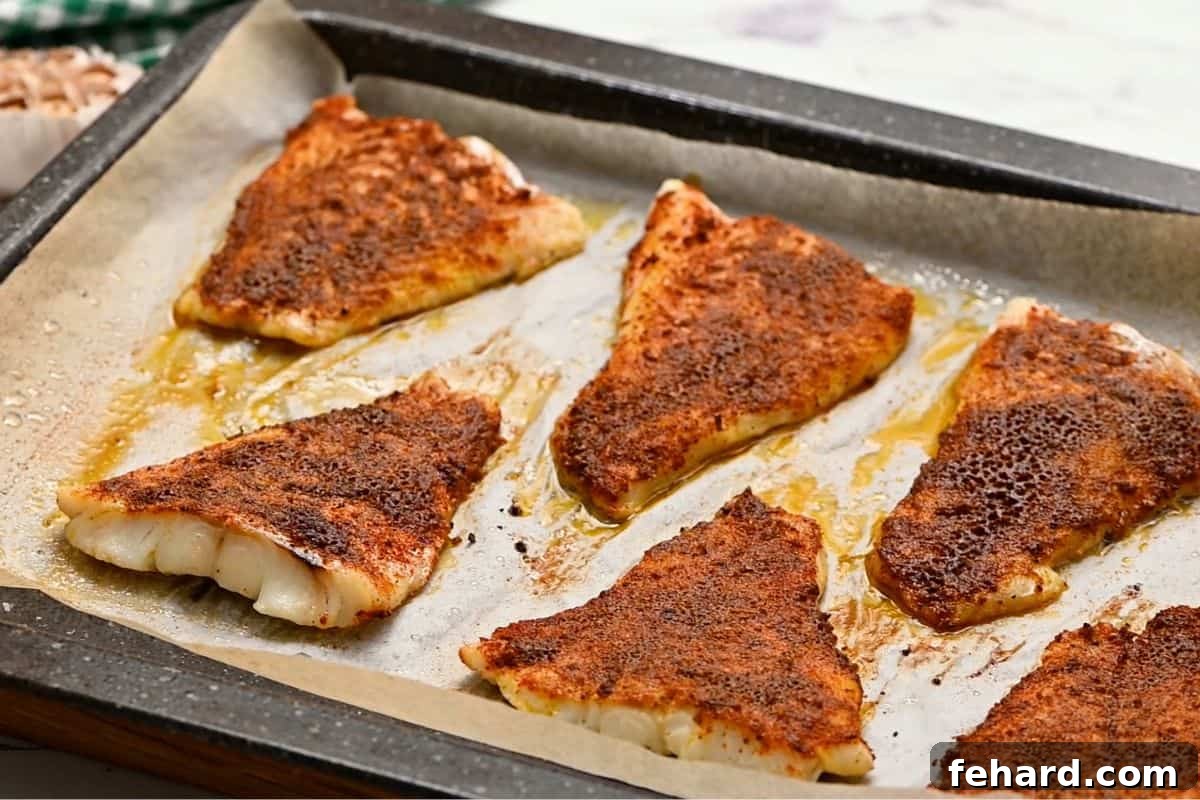 Baked Fish for Healthy Tacos Perfectly seasoned white fish fillets baking to a golden color on a parchment-lined sheet pan, ideal for healthy fish tacos.