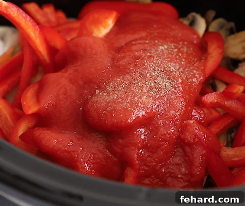 closeup view of Italian sausage and bell peppers in a slow cooker bowl