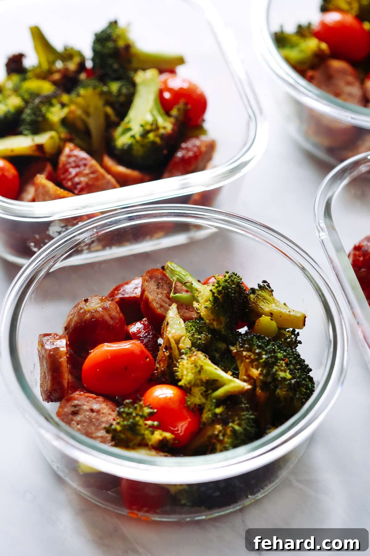 A close-up view of a One-Pan Italian Sausage Meal-Prep Bowl, showcasing the roasted sausage, broccoli, and cherry tomatoes.