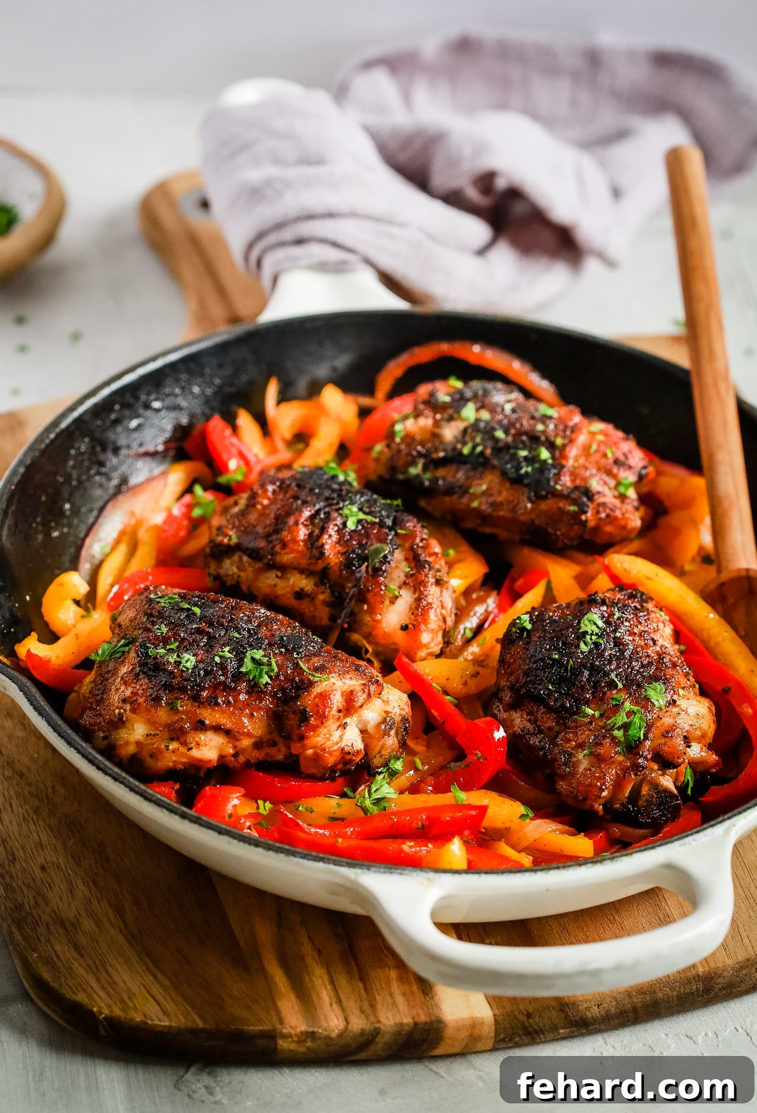 Crispy skin chicken thighs and vibrant bell peppers in a skillet