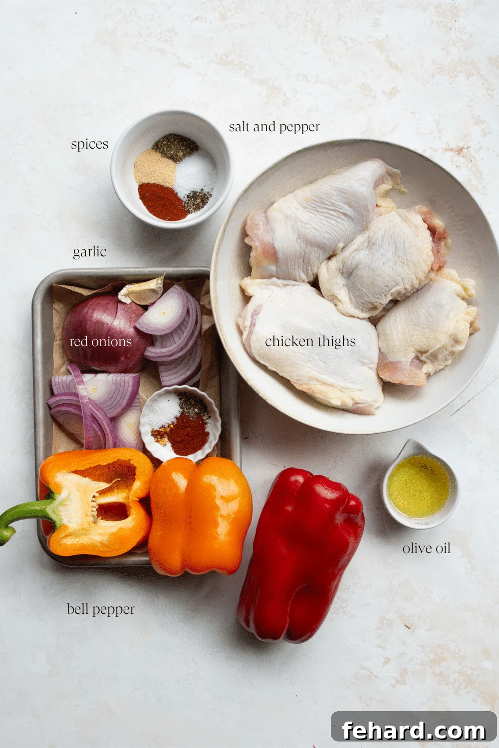 Ingredients laid out for cooking chicken thighs and bell peppers