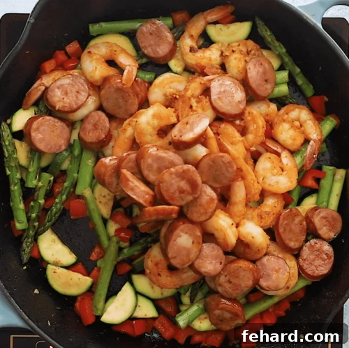 overhead view of a cast iron skillet containing shrimp and sausage