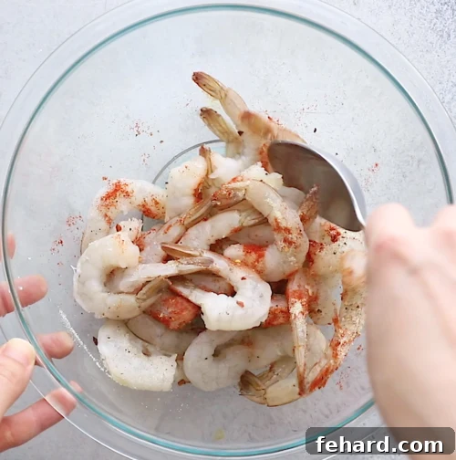overhead view of a large glass bowl containing shrimp and spices