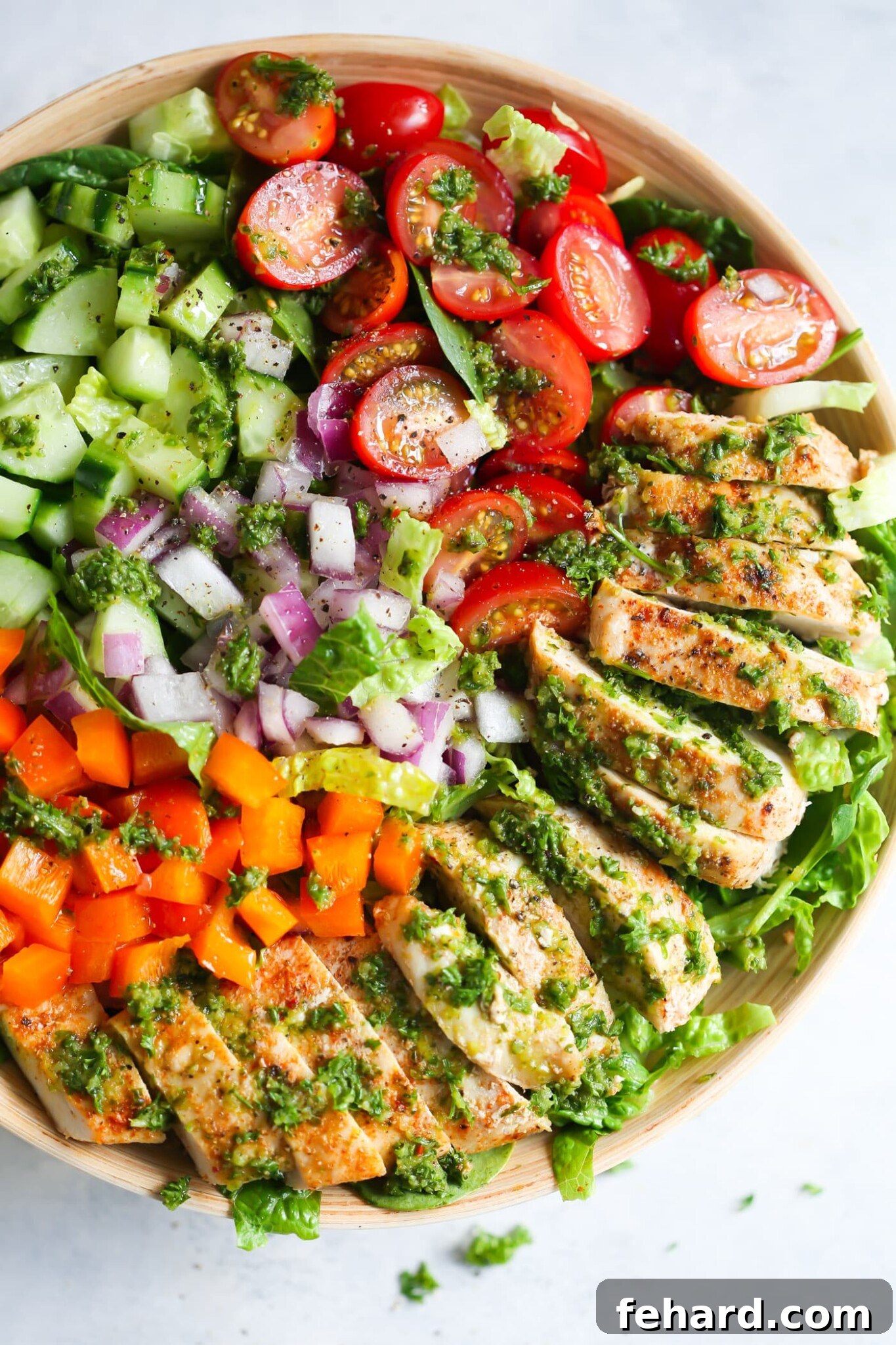 Chimichurri chicken chopped salad in a large bowl, bursting with fresh ingredients like bell peppers, cucumber, and grilled chicken.