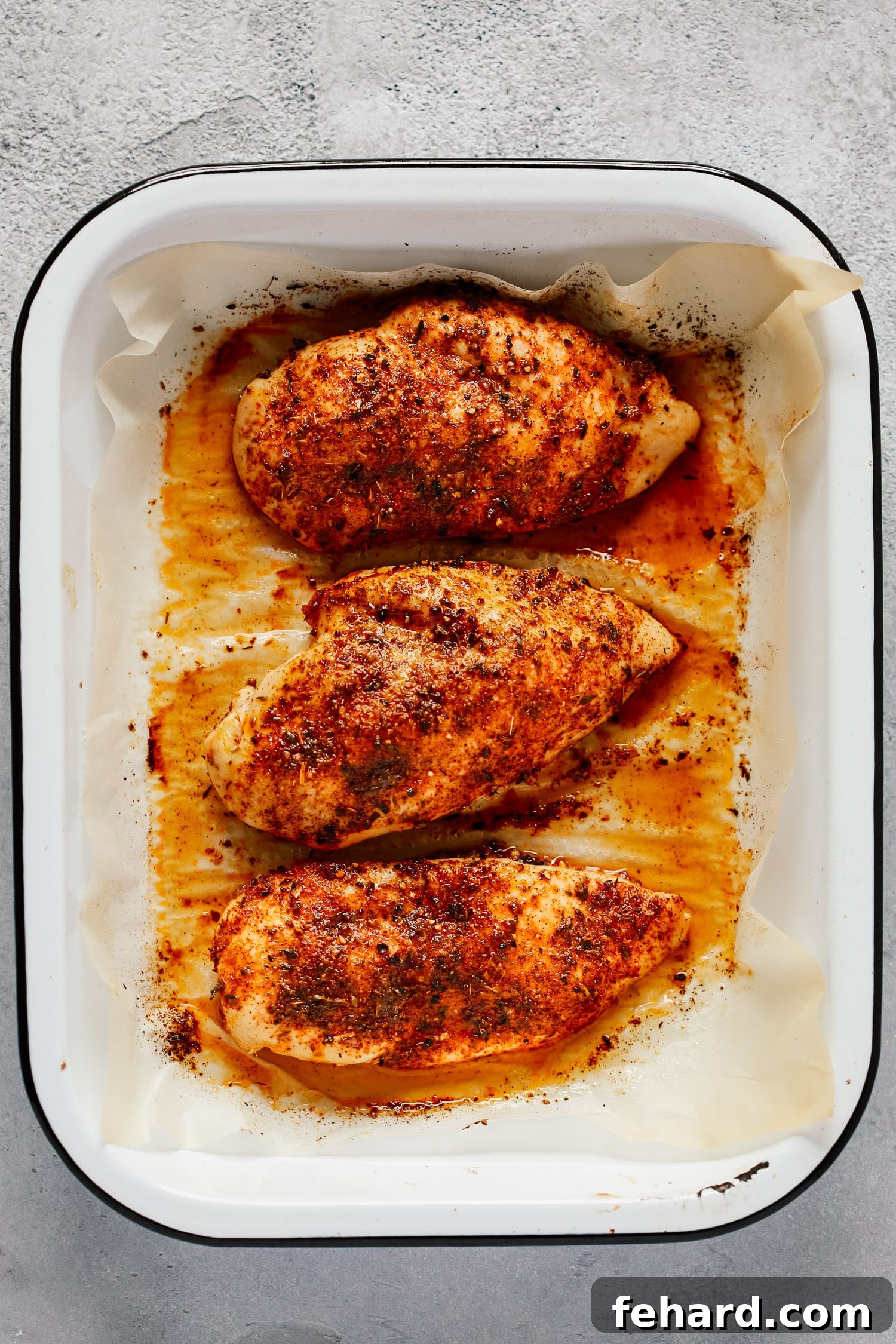 A perfectly cooked, golden-brown baked chicken breast, seasoned with herbs and ready to be served or incorporated into other dishes.