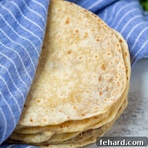 Flour tortillas wrapped in a blue kitchen towel.