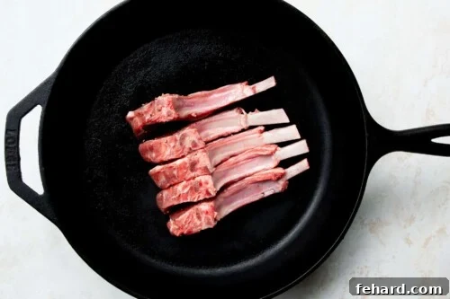 raw lamb chops in a cast iron skillet 