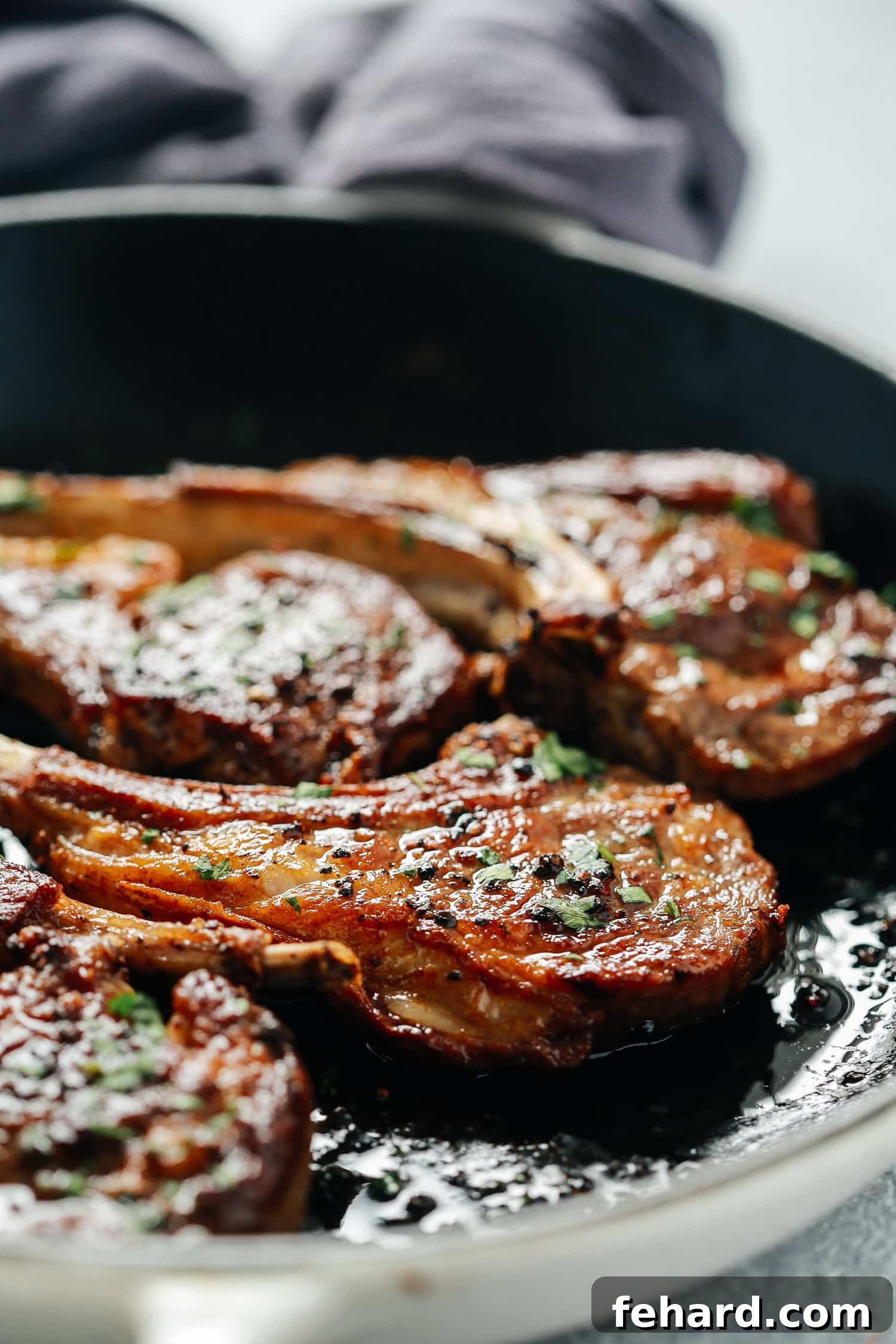 Close-up view of perfectly seared lamb chops, showing the golden-brown crust and tender interior.