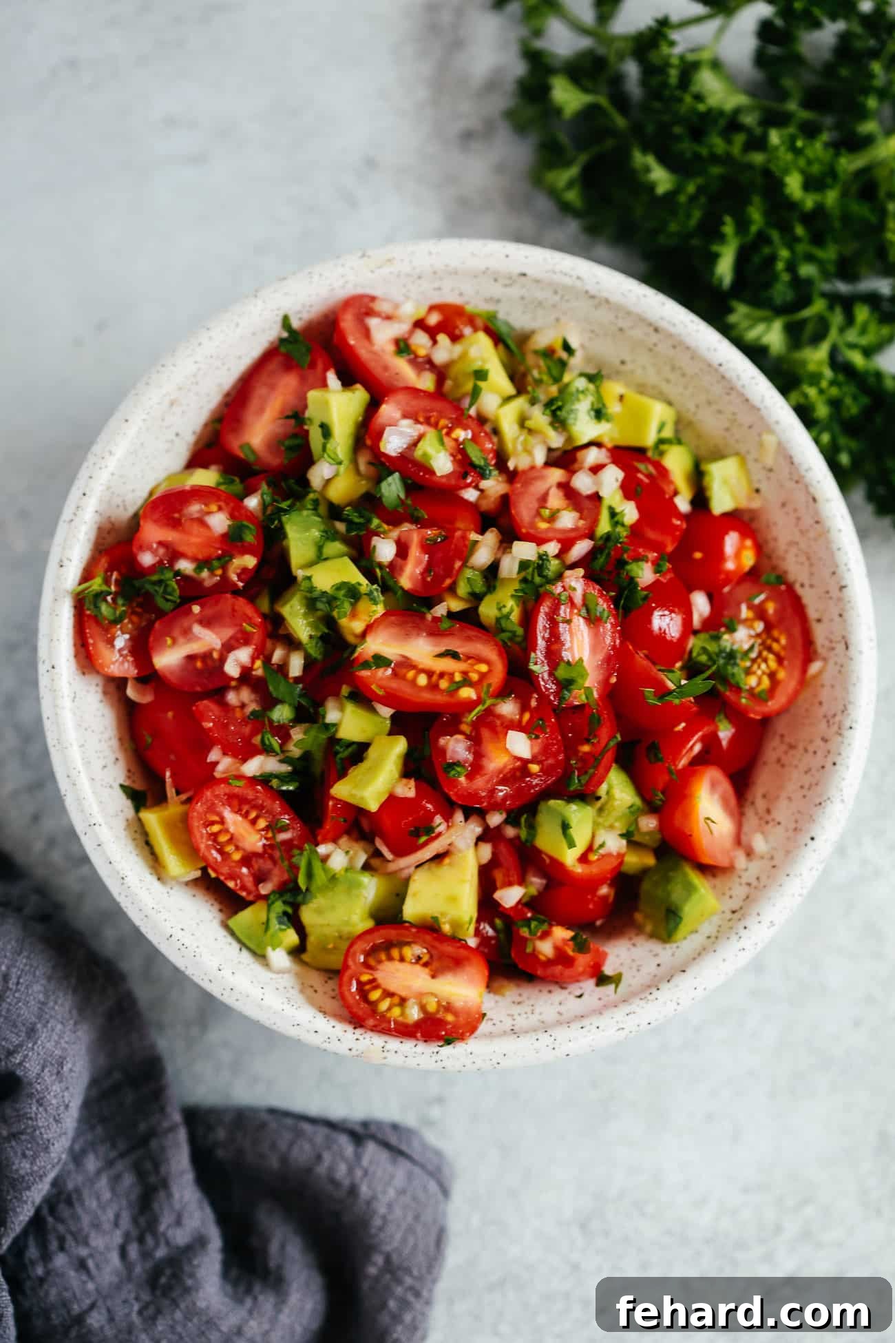 Vibrant Avocado Tomato Salad 2 An overhead photo of a vibrant avocado tomato salad in a white bowl, ready to be served.