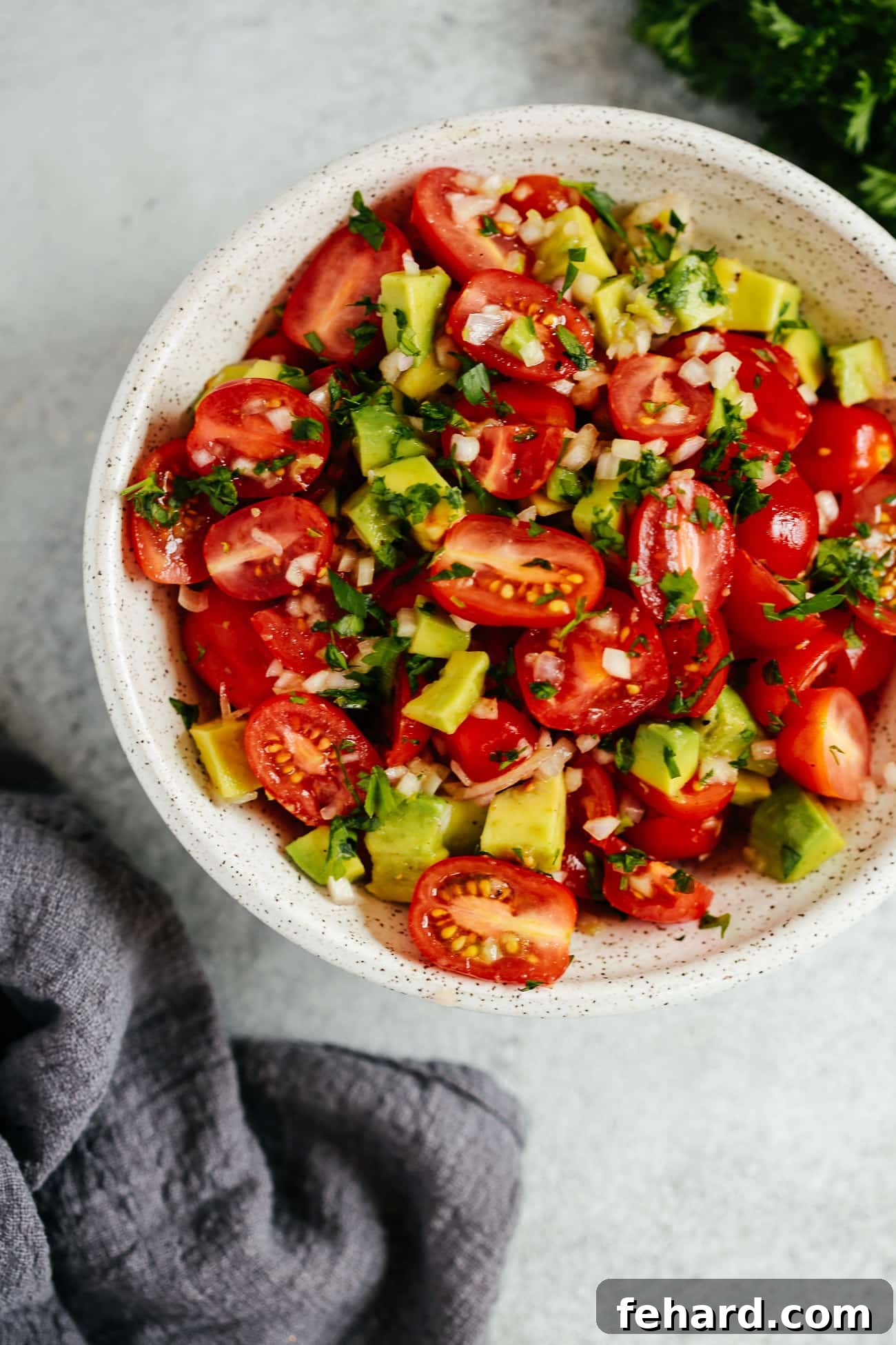 Vibrant Avocado Tomato Salad 3 A close-up shot of a colorful tomato salad with visible herbs and a light dressing.