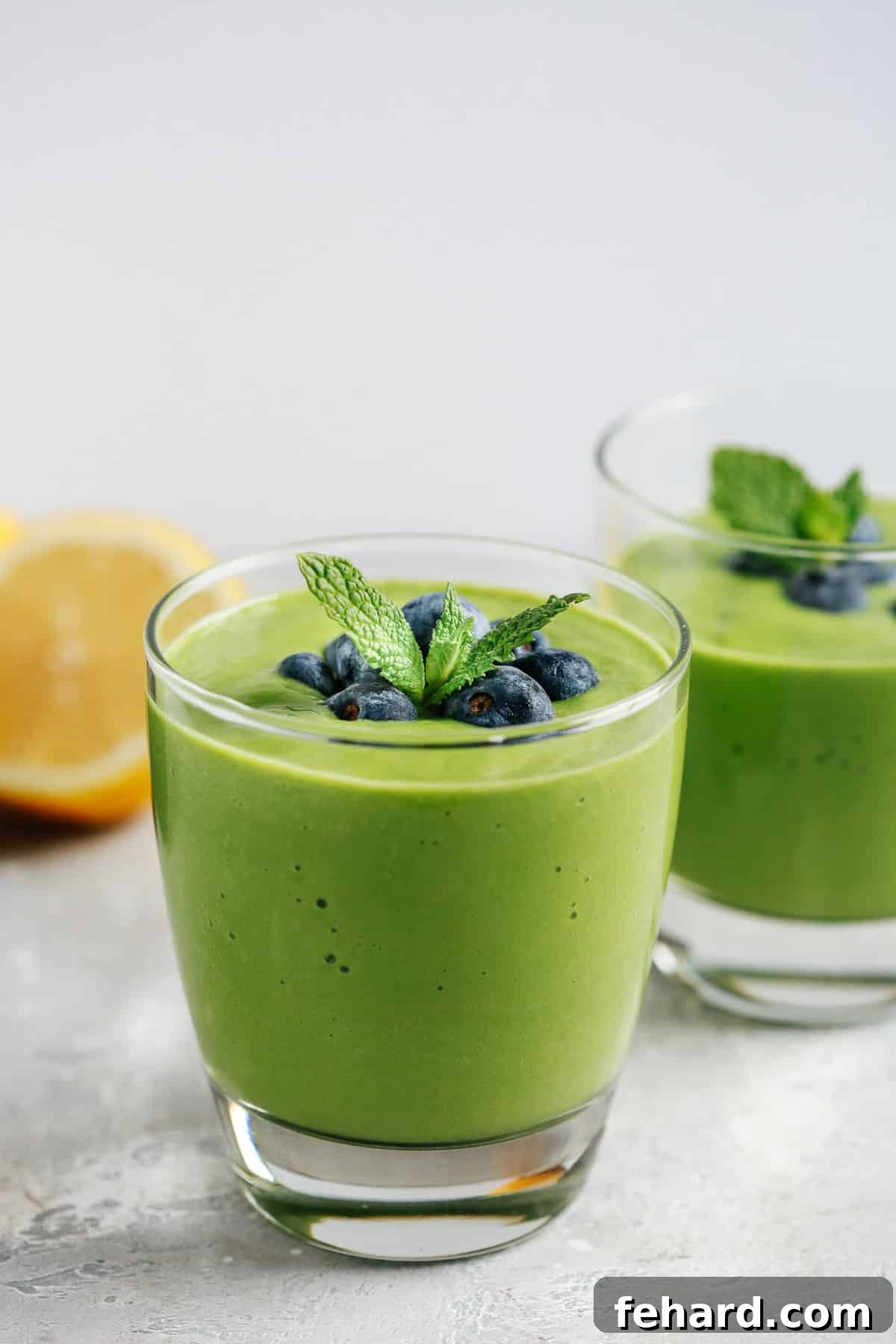 A refreshing green breakfast smoothie served in a short juice glass, ready to energize your morning.