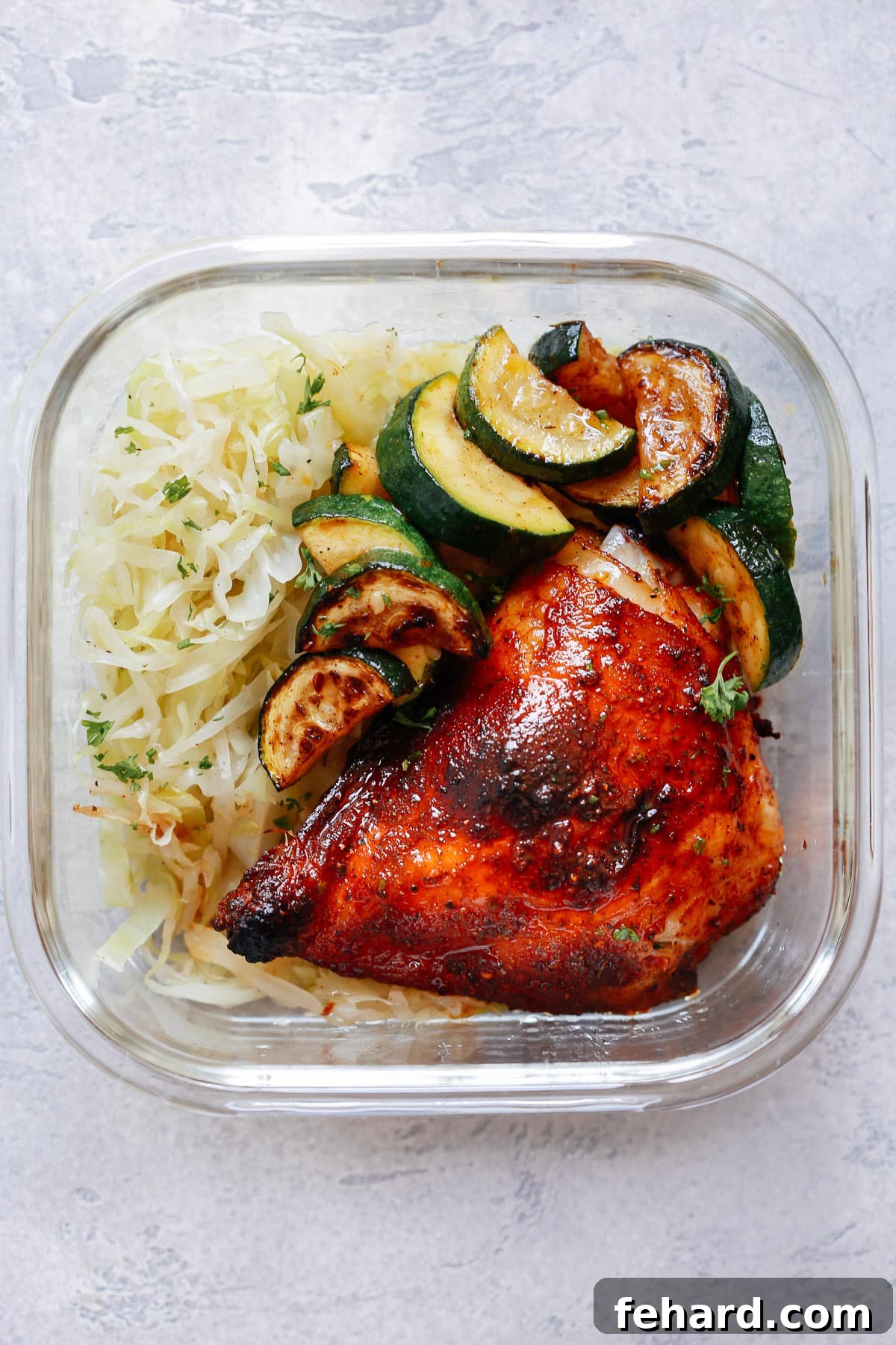 Spicy Chicken with Sauteed Cabbage and Zucchini in glass meal prep container