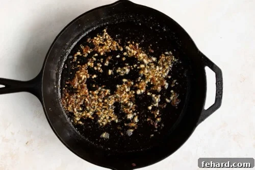 Garlic and butter simmering together in a cast iron skillet.