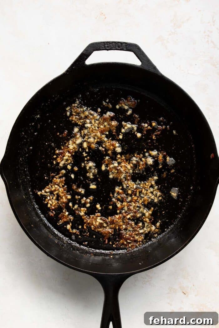 Minced garlic and melting butter sizzling in the skillet, forming the base of the sauce.