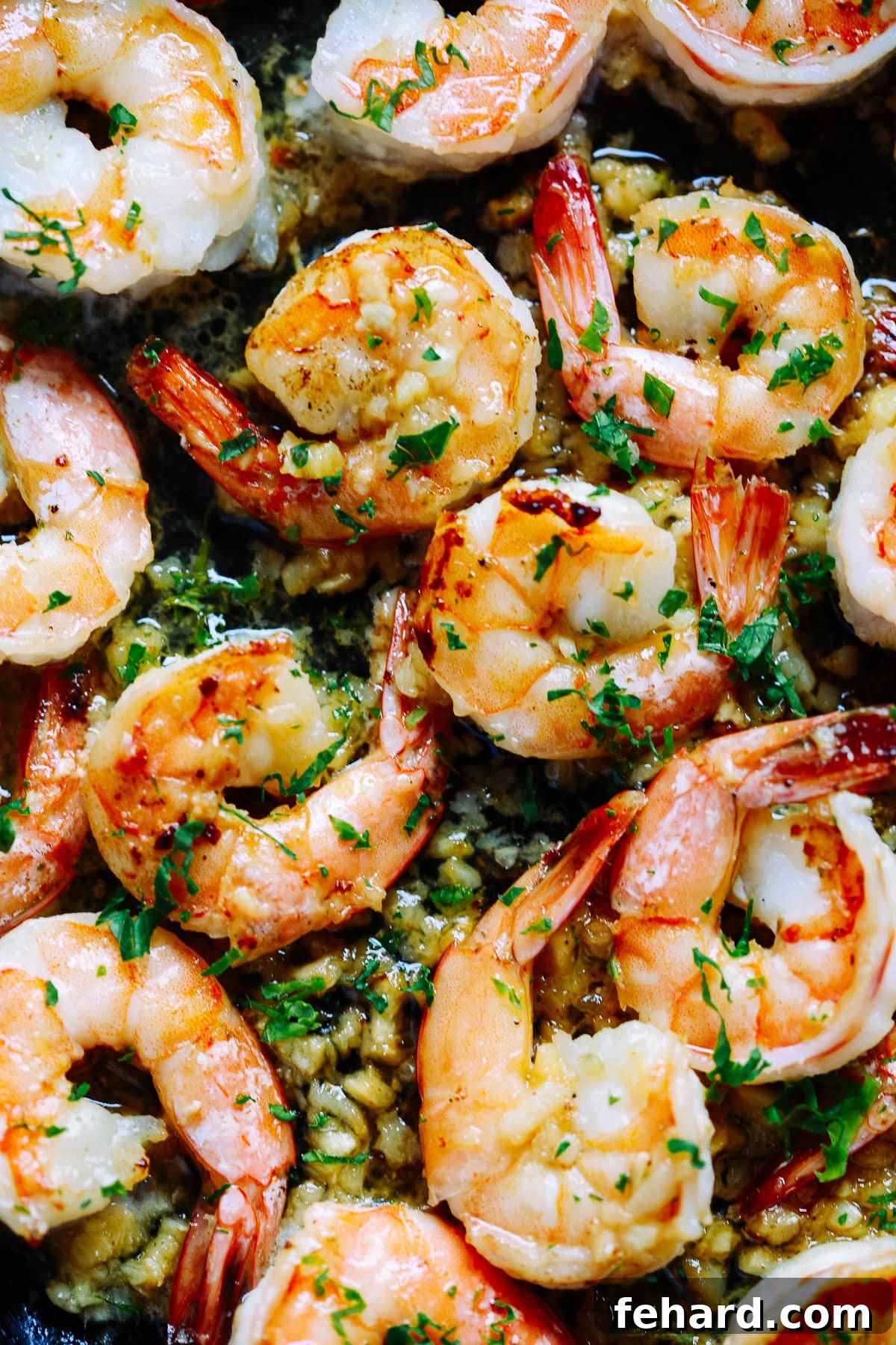 Close up image of perfectly cooked garlic butter shrimp, ready to be served.
