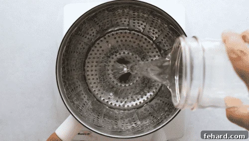 Overhead view of someone filling a pan with water for steaming