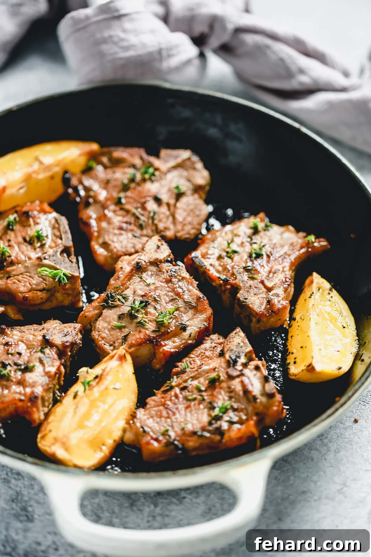 Plated Lemon Thyme Lamb Chops garnished with fresh lemon wedges and sprigs of thyme