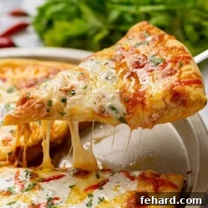 Slice of Buffalo pizza being pulled off pizza showing cheese pull.