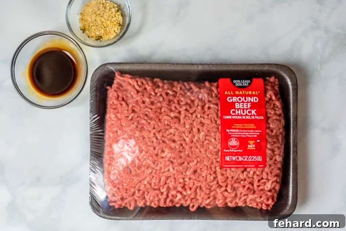 A package of high-quality ground chuck alongside bottles of Worcestershire sauce and a packet of dry onion soup mix, highlighting key burger ingredients.