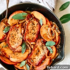 Skillet pork chops with apple slices, onions, and fresh herbs.